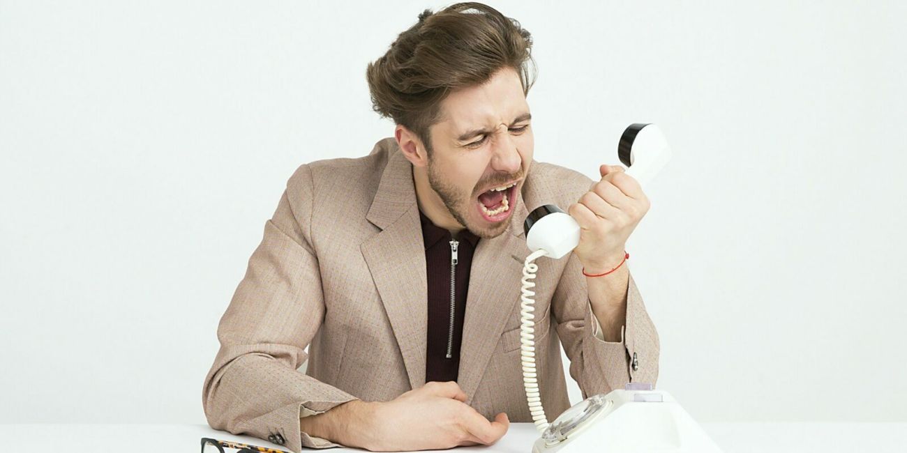 mann schreit in ein Telefon