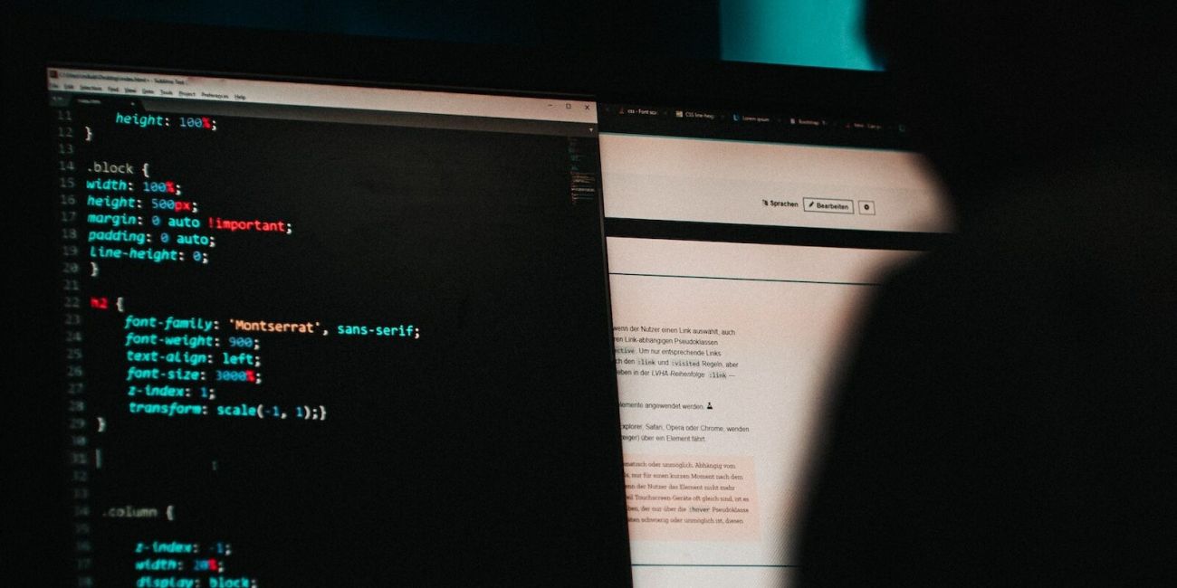 Hacker sitzt vor Bildschirm mit Code darauf