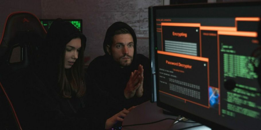 Zwei Hacker arbeiten an einem Bildschirm